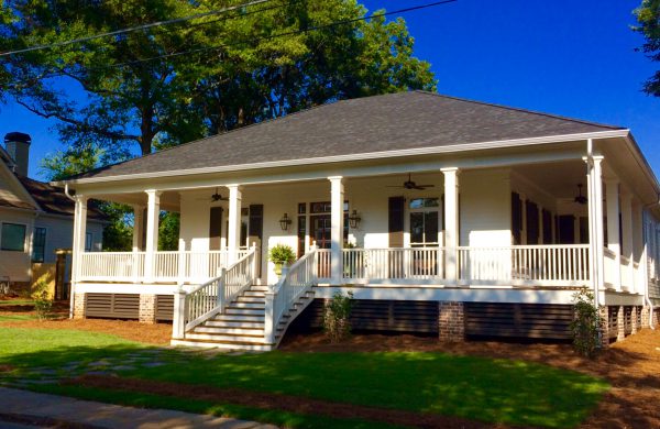 White custom home with a columned wraparound porch and front steps
