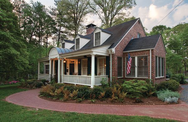 Brick custom home with a wraparound porch and curved brick walkway