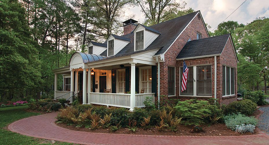 Brick custom home with a wraparound porch and curved brick walkway